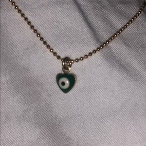 Gold necklace with green evil eye